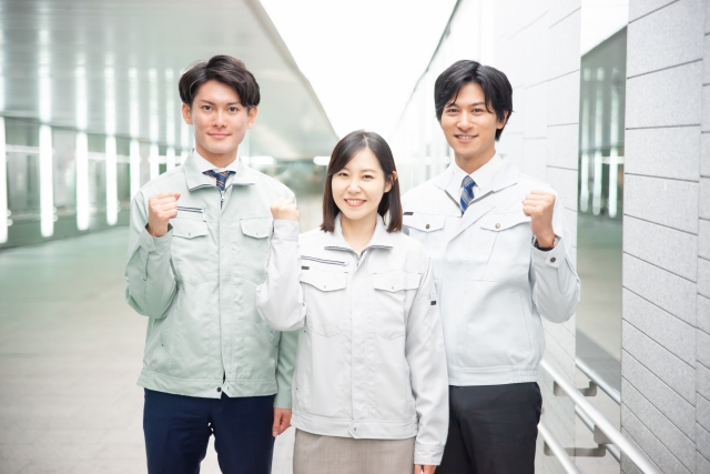 オフィスでユニフォーム姿の三人の笑顔